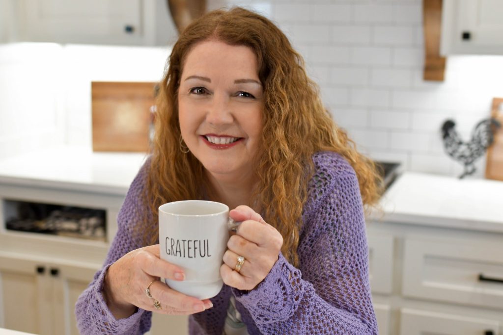 Debbie DeMoss Compton holding a grateful mug