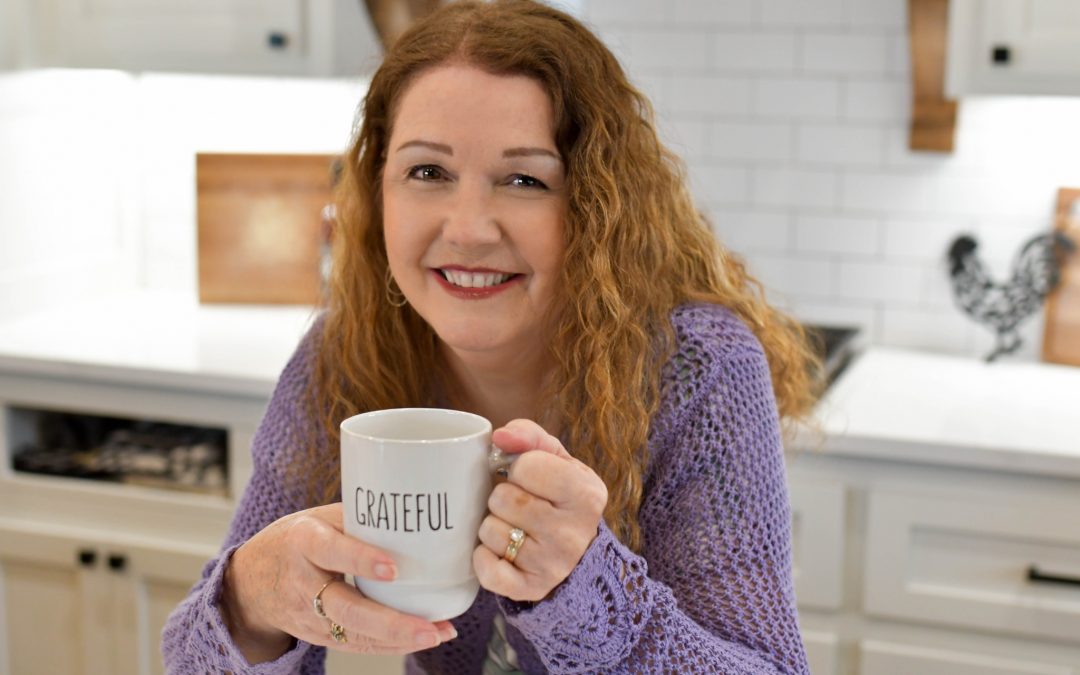 Debbie DeMoss Compton holding a grateful mug